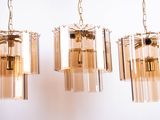 three glass chandeliers hanging from a ceiling in a room