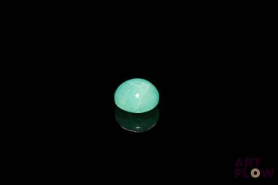a close up of a glowing green ball on a black surface
