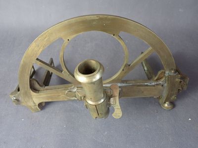 un télescope ancien plaqué laiton posé sur une surface grise