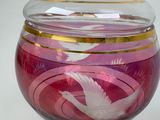 a glass container with a bird on it on a table