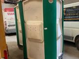 des toilettes portables vertes et blanches installées dans un garage