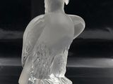 a glass figurine of a bird with a hat on it