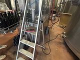 a ladder that is next to a bunch of bottles of wine