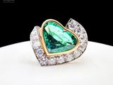 an image of a ring with a heart shaped green stone