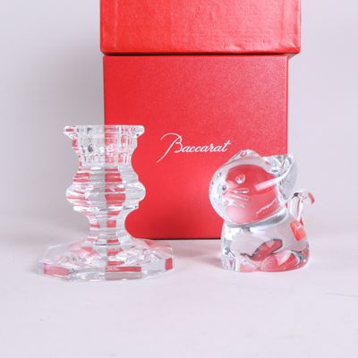two glass candlesticks sitting next to a red box