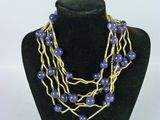 Collier composé de perles violettes et de fil d'or, présenté sur un mannequin