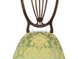 une image représentant une chaise dont l'assise est recouverte d'un tissu vert et doré