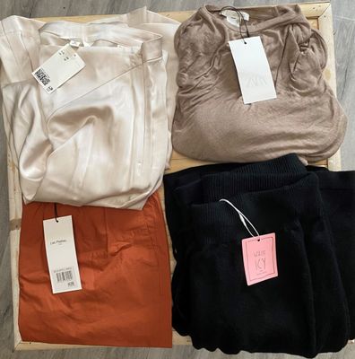 three pairs of pants and a t - shirt sitting on a wooden box