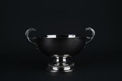 une image représentant une coupe en argent avec une anse en forme de dragon sur fond noir