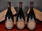 three bottles of wine sitting next to a wooden box on a table