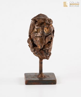 une image représentant une sculpture représentant une tête d'homme posée sur un socle en bois