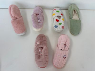 Plusieurs paires de chaussons sont alignées sur une surface blanche