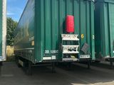 deux semi-remorques vertes garées côte à côte sur un parking