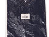 Le t-shirt est noir et comporte une étiquette blanche