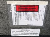 a sign on the back of a suitcase that says caution