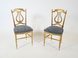 pair of chairs with a blue upholstered seat and a gold frame