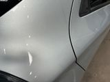 a close up of a car ' s front bumper with a denting on it
