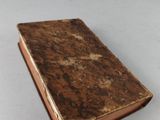 an old book sitting on top of a table next to a white table
