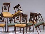 six chaises, dont les dossiers sont rembourrés, sont disposées en rangée