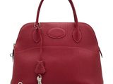 a red leather handbag with a lock on the handle