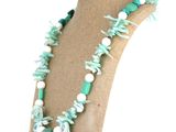 collier de coquillages verts et blancs, avec des perles et des feuilles vertes