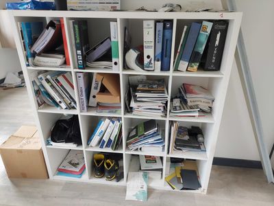a book shelf with many books on it in a room