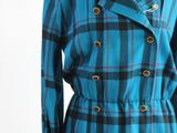 un manteau à carreaux bleus et noirs sur un mannequin, un mannequin, un mannequin, un mannequin, un mannequin, un mannequin, un mannequin, un mannequin