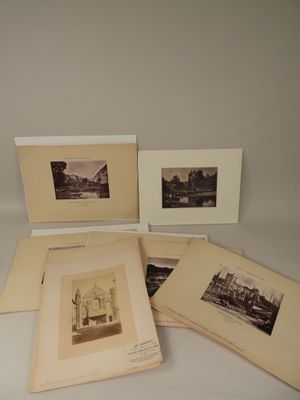cinq vieilles photographies représentant des bâtiments et un pont sont disposées sur une table
