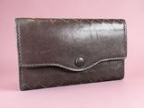 an image of a brown leather wallet on a pink background