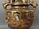 un vase doré et rouge muni d'un couvercle
