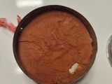 a pan of cake sitting on a table next to a cup of coffee
