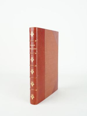 an old red book sitting on top of a white surface