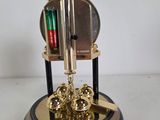 a clock that is sitting on a stand with a pen in it