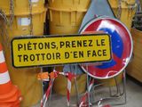 a sign that is in front of a bunch of orange and white cones