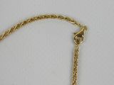 a close up of a gold bracelet on a white surface
