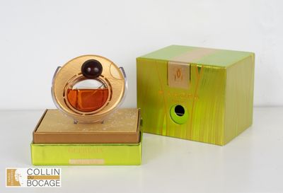 une image représentant un flacon de parfum posé sur une boîte