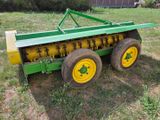 un tracteur vert et jaune garé dans l'herbe
