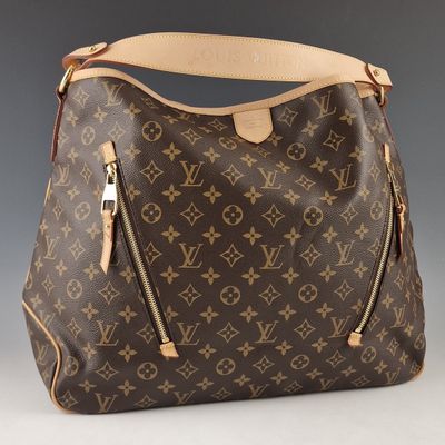 Un sac à main Louis Vuitton est présenté sur un fond gris