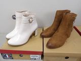 pair of women ' s white and brown ankle boots on top of boxes