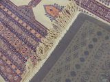 two rugs on the floor with a cat laying on top of them