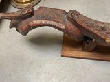 a wooden sculpture of a bird on a wooden stand