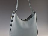 a blue leather handbag on a grey background