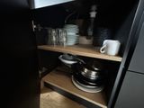 a black cupboard with dishes and cups on it