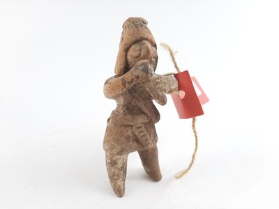 a small figurine of a man holding a red bag