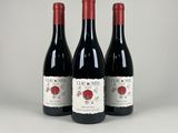 trois bouteilles de vin rouge posées côte à côte sur une table