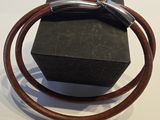 un bracelet en cuir marron muni d'un fermoir en argent, présenté dans un coffret noir