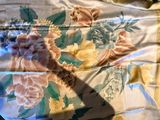 une photo d'un lit avec une couette à motifs floraux et une paire de ciseaux