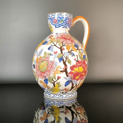 a vase with a floral design on it sitting on a table