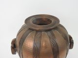 a brown vase that is sitting on a white surface