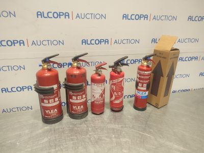 four fire extinguisors are lined up in front of a wall